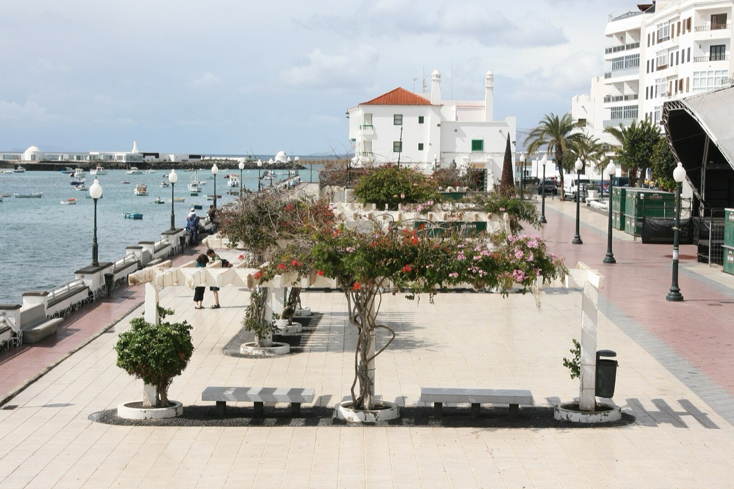 El Parque José Ramírez Cerdá, en el paseo marítimo de Arrecife: pérgola con buganvillas, bancos y la bahía con barcas al fondo (foto de un día corriente, no de la feria).