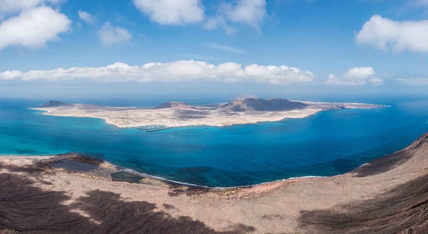 La Graciosa vista desde el Risco de Famara, rodeada por las aguas turquesa de la Reserva Marina.