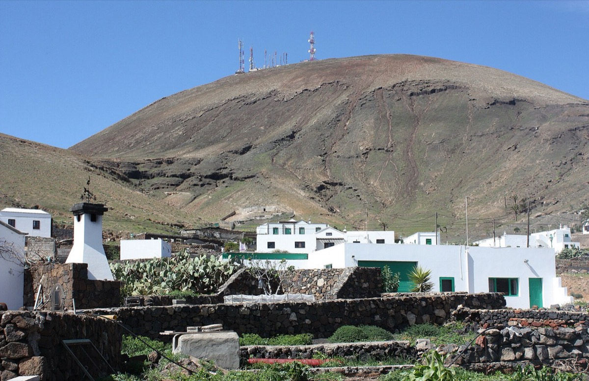 Casas blancas de Femés al pie de la Atalaya, con antenas en la cumbre
