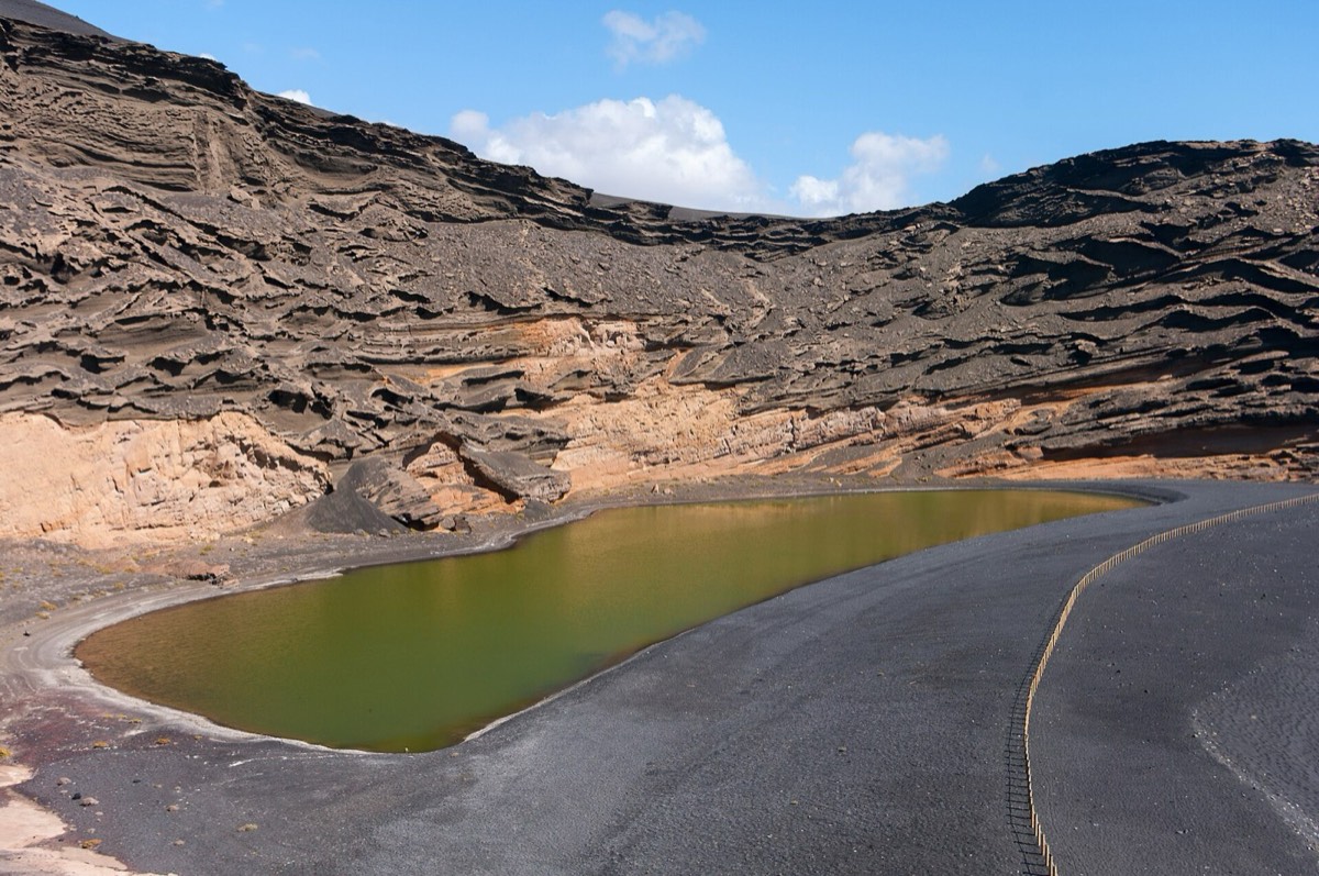 La laguna verde del Charco de los Clicos bajo las paredes estratificadas del cráter