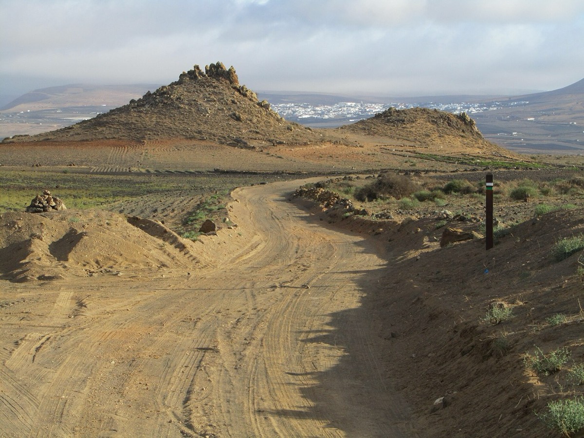 Pista de arena en El Jable de San Bartolomé, con un poste del sendero