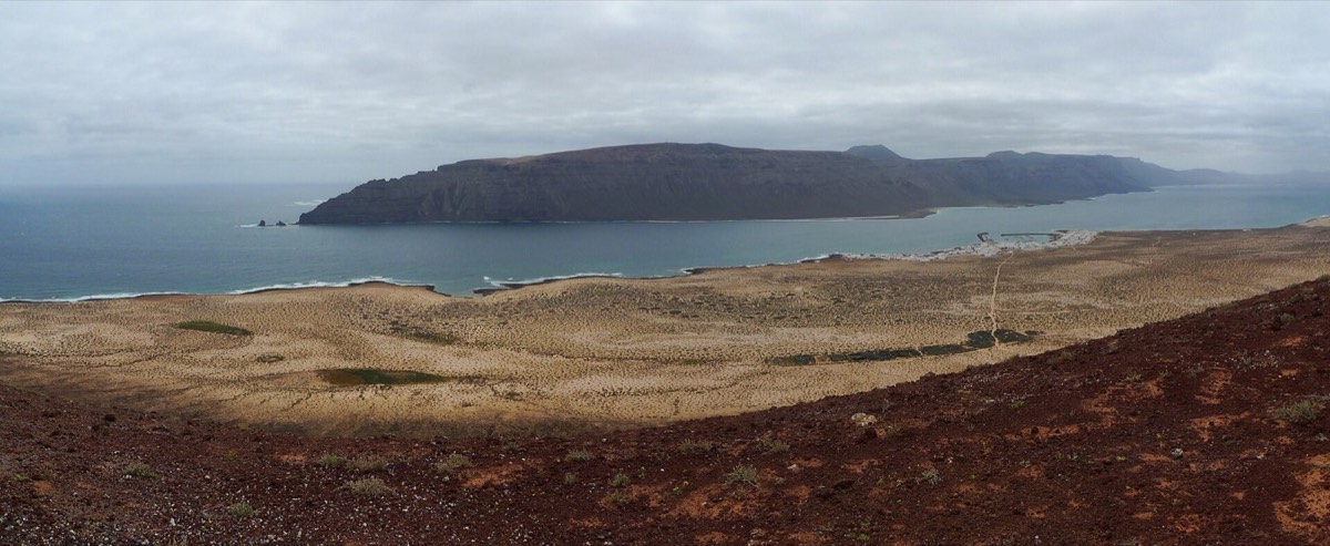Vista desde Agujas Grandes sobre la llanura de La Graciosa, el estrecho y los acantilados de Lanzarote