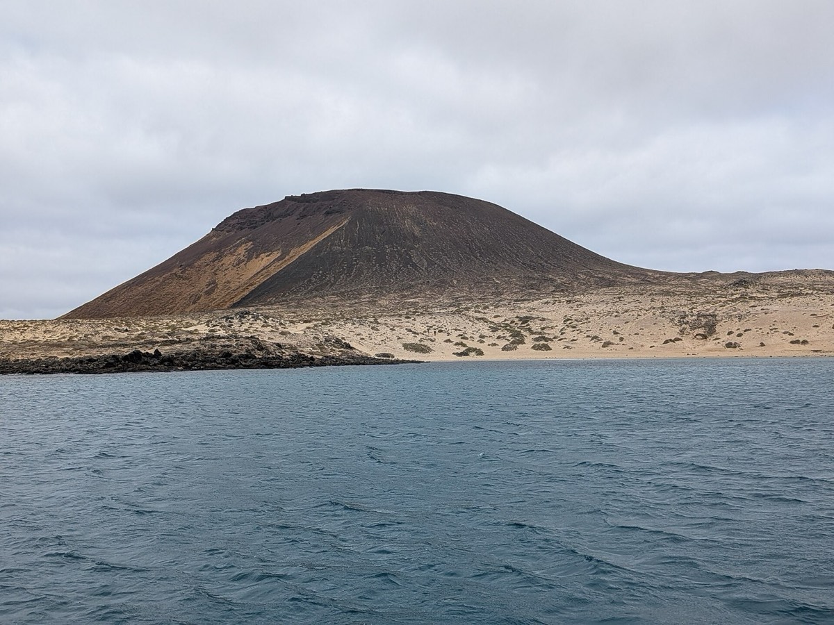 Montaña Amarilla vista desde el mar frente a Playa Francesa, con la ladera ocre sobre la arena