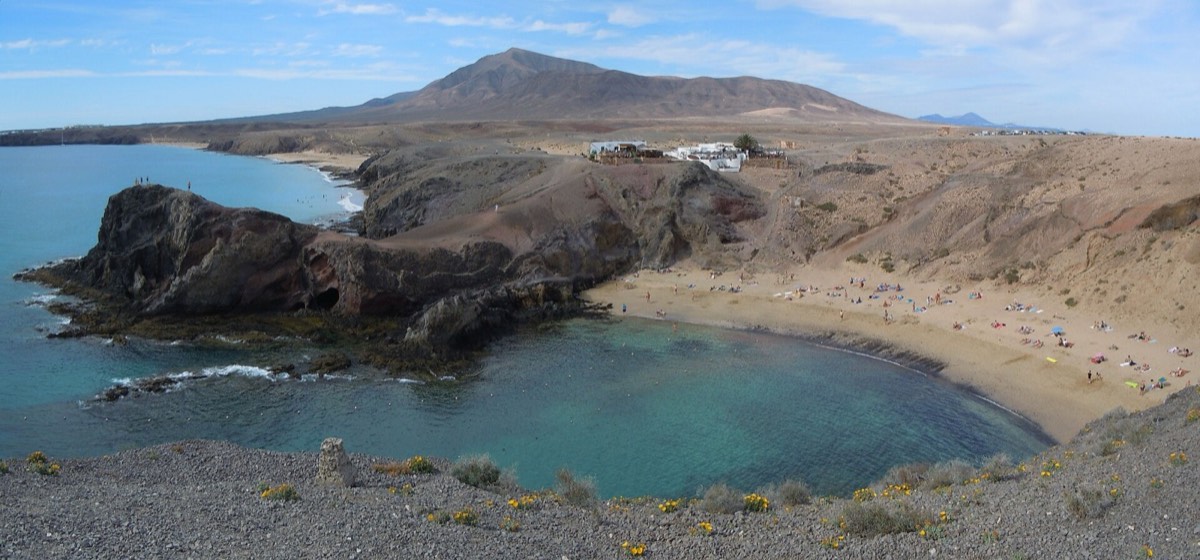 Playa de Papagayo, de agua turquesa, bajo las lomas de Los Ajaches
