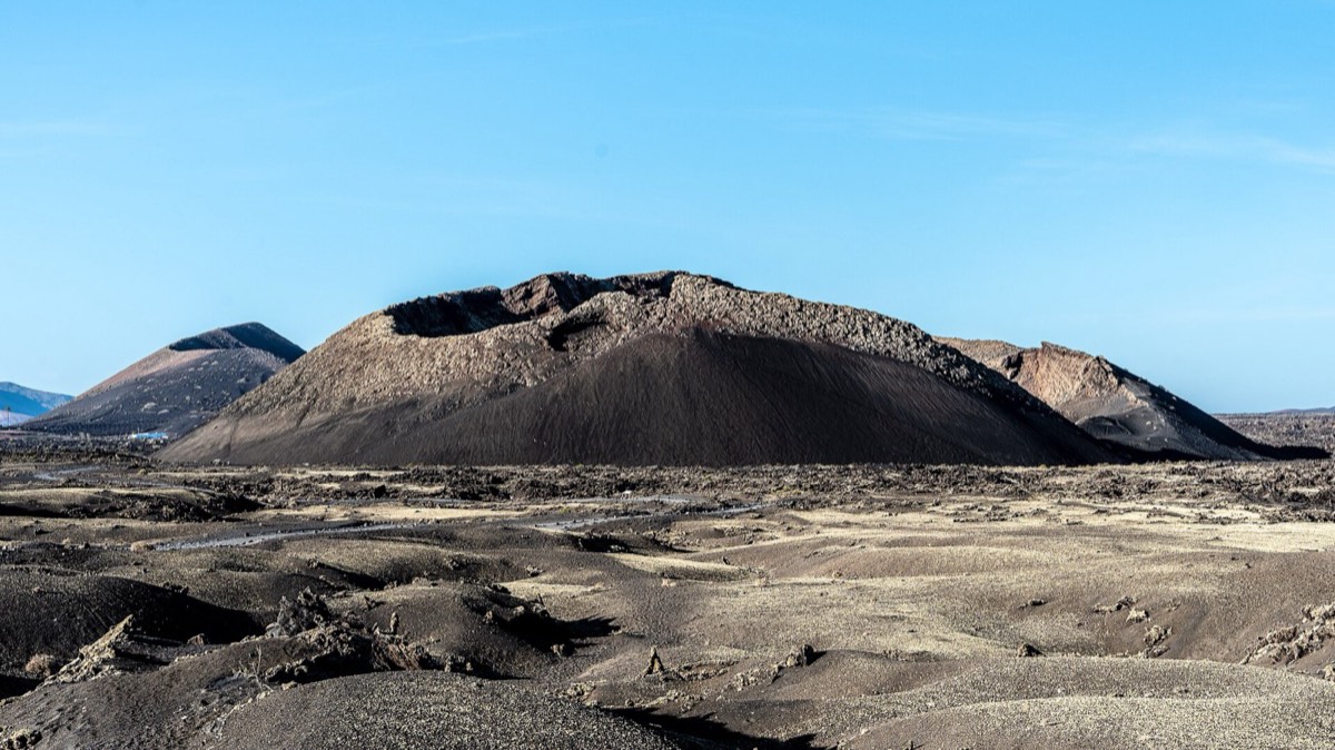 Cono de la Caldera de Los Cuervos sobre un campo de lava y lapilli, bajo un cielo despejado